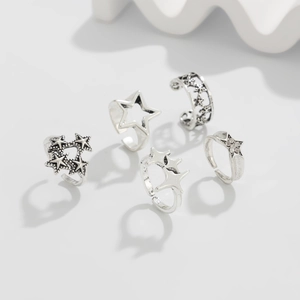 Dettaglio del set di cinque anelli a stella in argento vintage con incisioni e cristalli