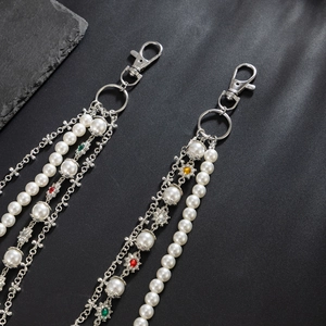Detail of silver layered pearl trouser chain with metal flower charms and lobster clasp