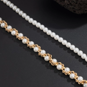 Nahaufnahme von weißen Perlen und goldener Metallkette für Streetwear Hip Hop Accessoires