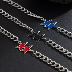 Dettaglio dei ciondoli a stella in smalto rosso, nero e blu su catene in stile cubano