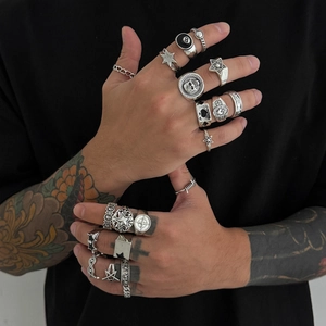 Nahaufnahme von Punk-Totenkopf- und Sternring-Set an Model mit Tattoos