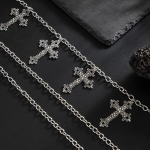 Detailed macro view of retro silver cross pendants on a heavy metal hip-hop waist chain
