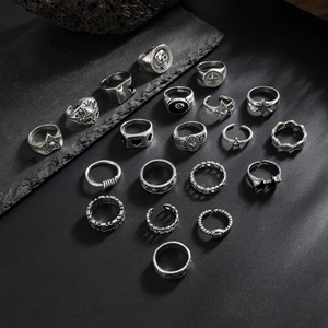 Detailansicht von Vintage-Silberringen mit Totenkopf und Stern auf Schieferplatte