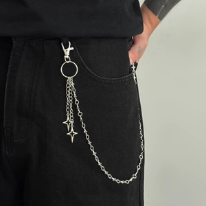 Close-up of punk style multi-layer silver trouser chain with four-pointed star charms