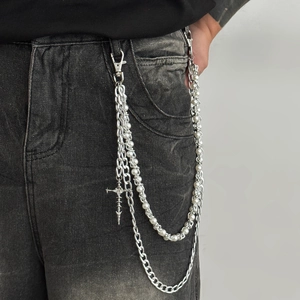 Detail of gothic pants chain with cross pendant, silver links and layered pearls
