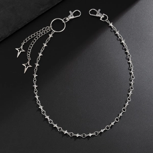 Detail of punk style silver star chain belt with metal pendants and lobster clasps
