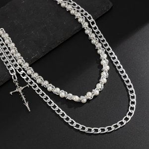 Detail of layered hip-hop chain with pearls and textured silver cross pendant charm