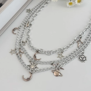 Detail of multi-layer silver alloy chain with celestial sun moon and star pendants