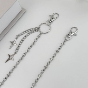 Macro detail of punk metal pant chain with lobster clasps and hollow star pendant