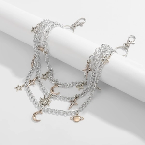 Detail of multilayer silver pant chain featuring vintage star and moon celestial pendants