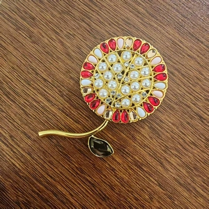 Elegante spilla a girasole con perle e strass colorati su uno stelo in metallo dorato