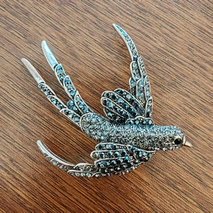 Vintage style swallow bird brooch featuring dark grey crystals on a silver metal base