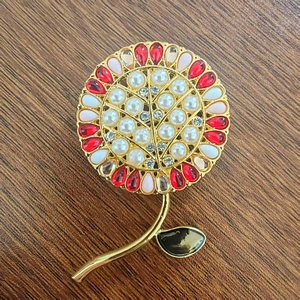 Elegante spilla a girasole con gemme rosse, rosa e perle bianche su metallo dorato