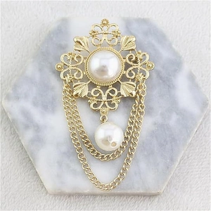 Vintage Baroque gold brooch with hollow floral design, white pearls, and long tassels