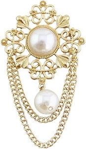 Close-up of vintage hollowed gold brooch with white pearl pendant and tassel chains