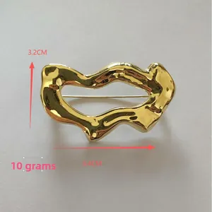 Vue détaillée de la broche dorée ajourée montrant les dimensions 3,2cm sur 5,4cm et le poids 10g