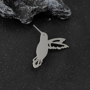 Spilla colibrì in argento minimalista con ali cave su pietra scura testurizzata