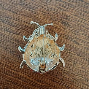 Vue arrière de la broche coccinelle plaquée or avec détails de moulage et fermoir