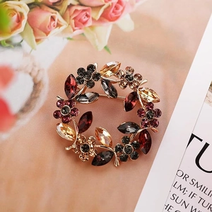 Detailed close-up of a vintage crystal wreath brooch with multi-colored gemstones