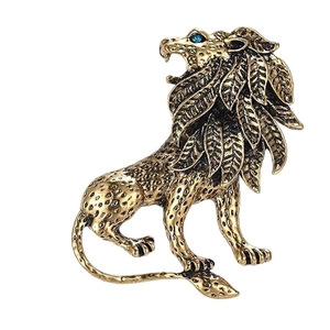 Vintage gold lion brooch with layered mane textures and a striking blue gemstone eye
