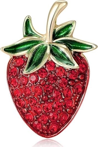 Close-up of strawberry brooch with red rhinestones and green enamel on golden alloy