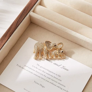 Detail of elegant gold elephant brooch with sparkling rhinestones on vintage paper