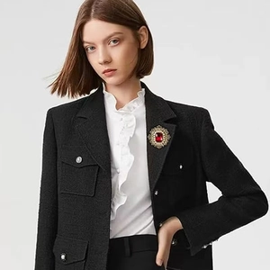 Detailansicht der Vintage-Brosche mit rotem Edelstein und Perlen auf einem Tweed-Blazer