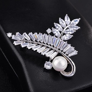 Elegant silver olive leaf brooch with zircon crystals and round pearl on black leather