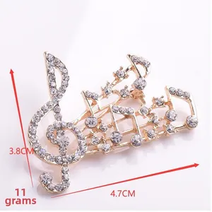 Vue détaillée de la broche en forme de clé de sol avec strass blancs et base dorée