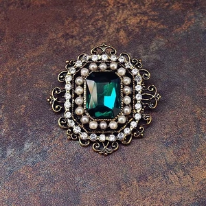 Detailansicht der Vintage-Brosche mit Smaragd-Stein, Perlen und Strass