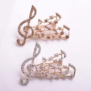 Macro de broches notes de musique dorées avec des strass champagne et blancs scintillants