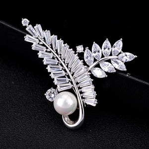 Elegant leaf-shaped brooch with silver zircons and a large white pearl on jewelry box