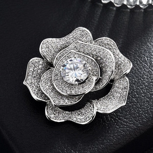 Macro detail of high-end zircon rose brooch with silver plating on black leather