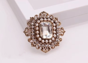 Detailansicht der Vintage-Brosche mit rechteckigem Kristall und Kunstperlen in Goldfassung