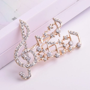 Détail de la broche note de musique dorée ornée de strass étincelants et de fins cristaux