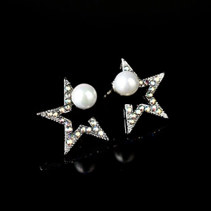 Macro shot of silver star stud earrings featuring center pearls and colorful rhinestones