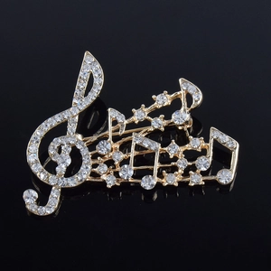 Détail de la broche note de musique plaquée or sertie de strass clairs scintillants