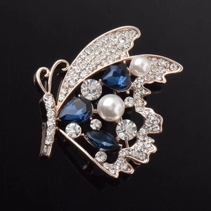 Vue macro détaillée d'une broche papillon élégante avec saphirs bleus et perles blanches