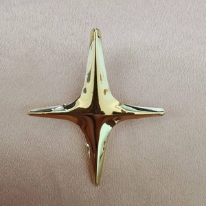 Élégante broche en forme d'étoile dorée sur un fond de tissu texturé rose doré de luxe