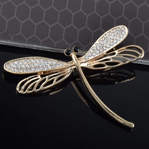 Macro shot of dragonfly brooch with clear rhinestones and golden hollowed wings