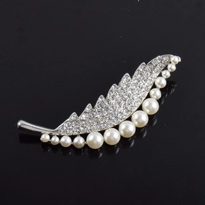Détail de la broche en forme de feuille avec base argentée et perles blanches