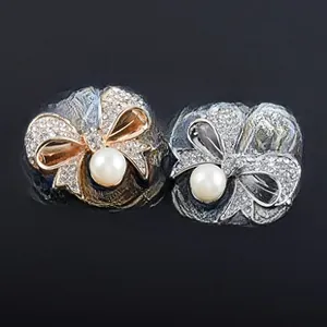 Détail de broches en cristal en forme de nœud, dorées et argentées avec perles d'imitation