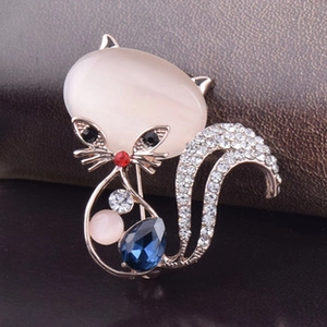 Macro d'une broche chat dorée avec pierre œil-de-chat et pierres précieuses colorées
