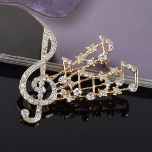 Vue détaillée de la broche note de musique sertie de strass sur surface noire polie