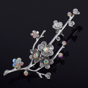 Elegant silver plum blossom brooch with colorful rhinestones on a black background