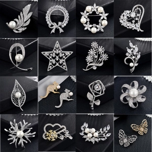 Collection of sixteen zircon and pearl brooches in leaf and floral patterns on black leather