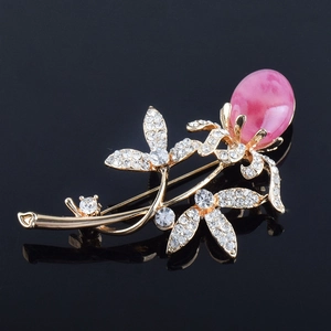 Detailansicht einer Blumenbrosche mit weißen Strasssteinen und rosa Marmorstein-Akzent