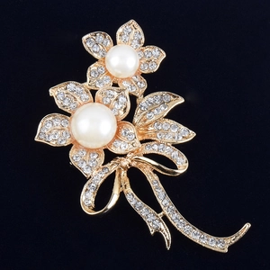 Élégante broche fleur dorée avec perles et strass sur fond noir profond