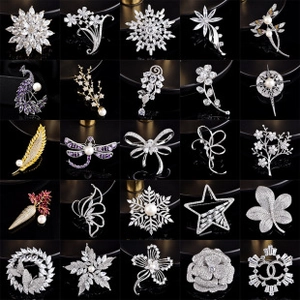 Collection of crystal flower and pearl brooches in assorted designs on black background