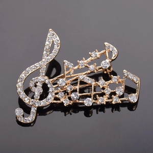 Détail macro de broche note de musique avec cristaux brillants sur base dorée